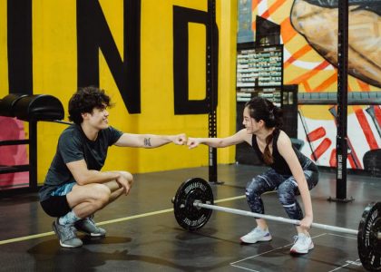 Man and woman in gym sharing a fist bump to celebrate a workout session.
